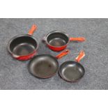 Four Le Creuset pans together with a tray containing brass wares including trivet, toasting fork,