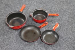 Four Le Creuset pans together with a tray containing brass wares including trivet, toasting fork,