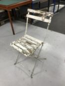 A painted folding metal chair with wooden slatted seat