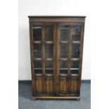 An oak linen fold glazed bookcase