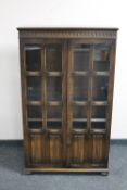 An oak linen fold glazed bookcase