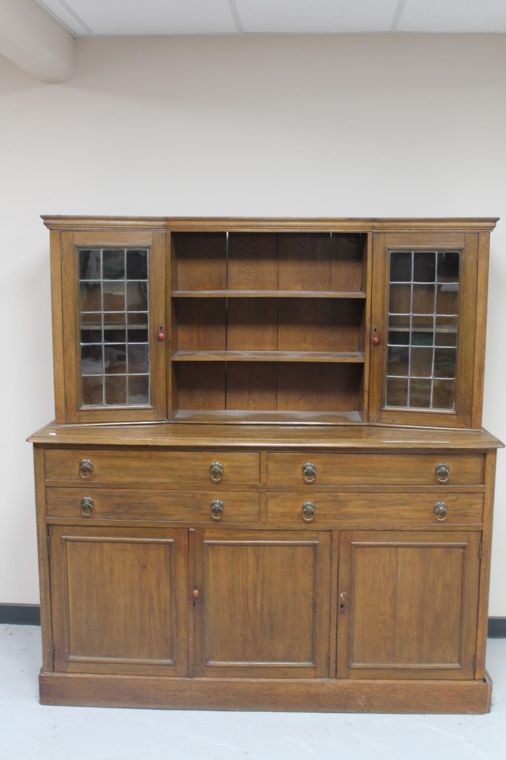 An oak leaded glass dresser fitted cupboards beneath