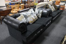 A pair of black studded leather two seater settees with scatter cushions