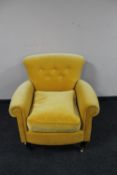 A contemporary armchair in buttoned lemon upholstery