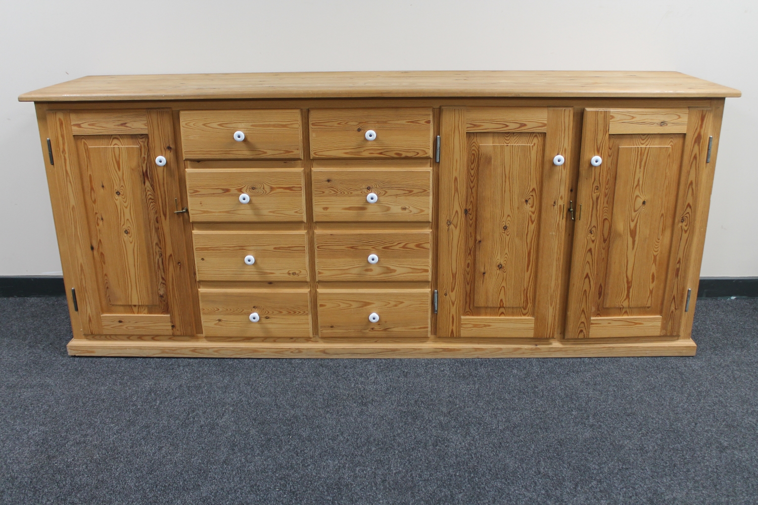 A pine dresser fitted cupboards and drawers beneath