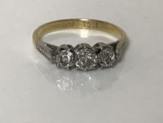 An 18ct gold diamond three stone ring, size L, approximately 0.33ct.