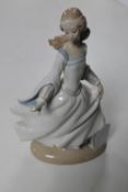 A Lladro figure of a lady in dress. CONDITION REPORT: Restored hand.