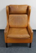 A mid 20th century Danish tan leather wingback armchair in the manner of Borge Mogensen