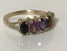 A 9ct gold multi stone ring set with sapphire, rhodalite, amethyst, garnet and peridot.