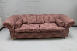 A good quality three seater settee, in purple floral upholstery with scatter cushions,