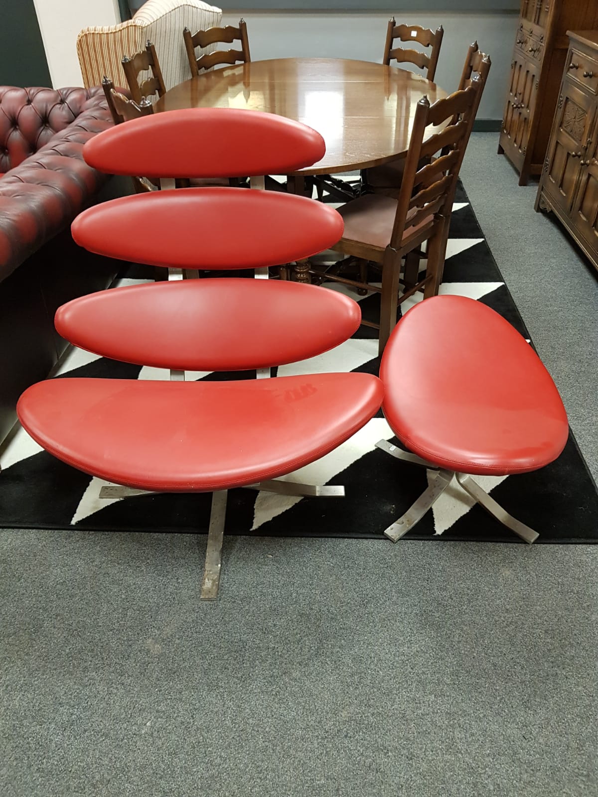 A contemporary red leather lounge chair with matching footstool CONDITION REPORT: