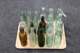 A tray of twenty assorted antique glass bottles and jars, many bearing advertising,