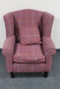 A wingback armchair in checkered purple upholstery