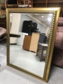 A contemporary gilt framed bevelled overmantel mirror