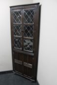 An oak leaded glass corner cabinet