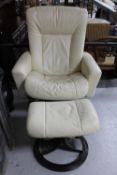 A cream leather swivel chair with matching footstool
