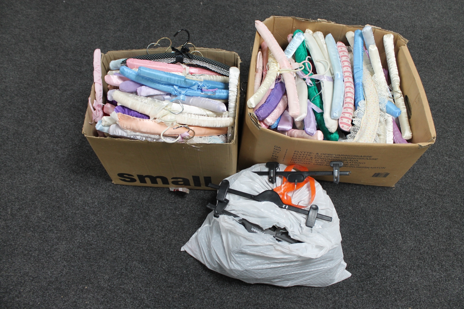 Two boxes containing a large quantity of padded coat hangers