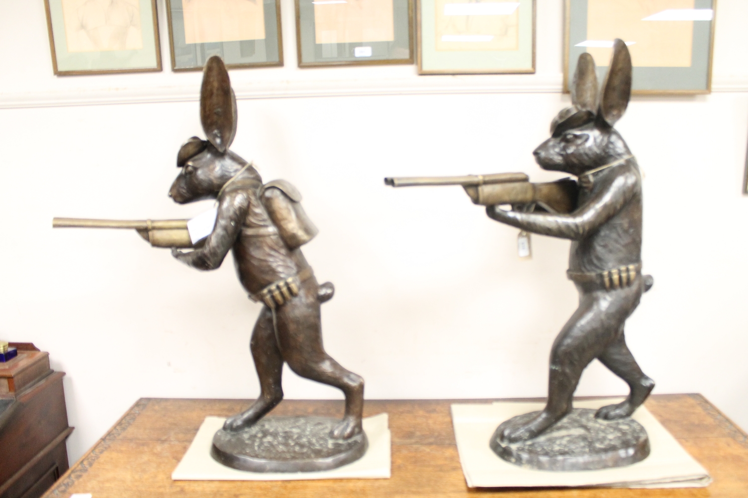 A pair of bronze figures - hares carrying shotguns,