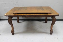 An oak extending dining table on carved legs