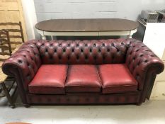 A red buttoned leather Chesterfield three seater settee