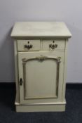 A cream and gilt single door cabinet fitted two drawers