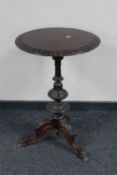 A heavily carved hardwood tripod table