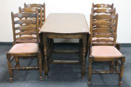 A Reprodux oak gate leg table and six ladder back dining chairs.