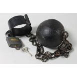 A cast iron ball and chain with padlock and key
