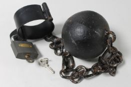 A cast iron ball and chain with padlock and key