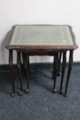 A nest of three mahogany tables with green tooled leather inset tops