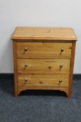 A pine three drawer chest