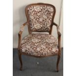 A carved beech framed salon armchair in floral fabric