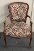 A carved beech framed salon armchair in floral fabric