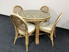 A circular bamboo glass topped conservatory table and four chairs