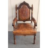 A 19th century heavily carved oak armchair in tooled leather (finial missing)