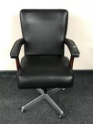 A black vinyl upholstered swivel office armchair