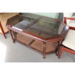 An octagonal mahogany coffee table with inset glass panels