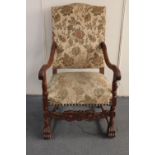 An early 20th century carved continental oak armchair in floral brocade