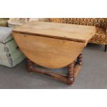 An antique oak gate leg table fitted a drawer