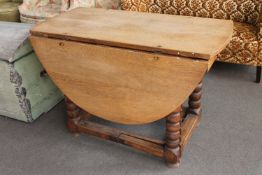 An antique oak gate leg table fitted a drawer