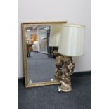 A chalk cherub table lamp and a gilt framed mirror