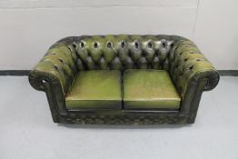 A green buttoned leather Chesterfield style two seater settee