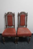 A pair of late 19th century heavily carved oak hall chairs