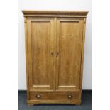 A pine double door hanging wardrobe fitted a drawer