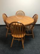 A circular pine kitchen table and four chairs