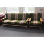 A blonde oak framed three seater settee and armchair in green striped fabric