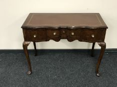 A shaped walnut writing desk fitted three drawers with brown leather inset panel