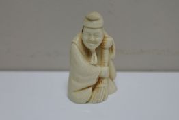 A resin netsuke - elderly gentleman with brush