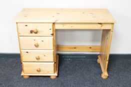 A pine dressing table fitted four drawers on bun feet