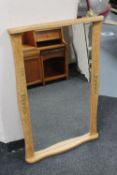 A continental blonde oak and gilt metal wall mirror